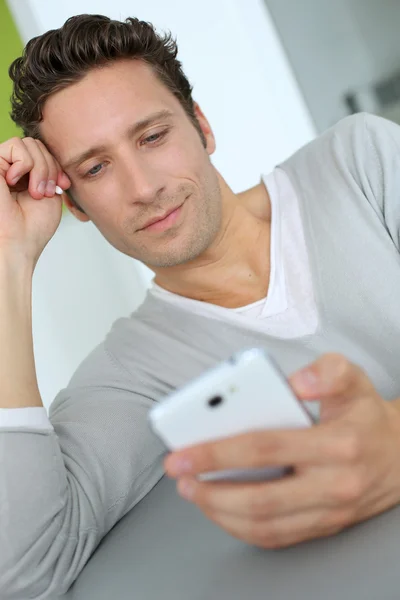 Человек расслабляется на диване и читает электронную почту — стоковое фото