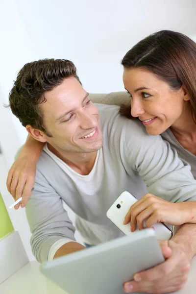 Casal alegre olhando para a internet no tablet — Fotografia de Stock