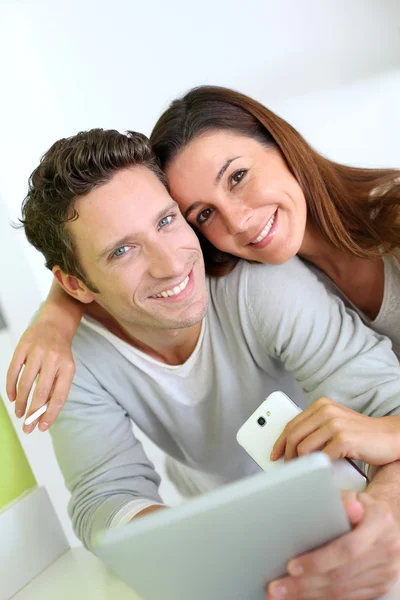 Casal alegre olhando para a internet no tablet — Fotografia de Stock