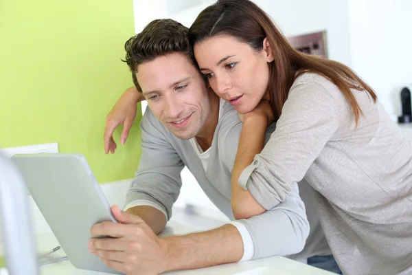 Cheerful couple looking at internet on tablet — Stock Photo, Image