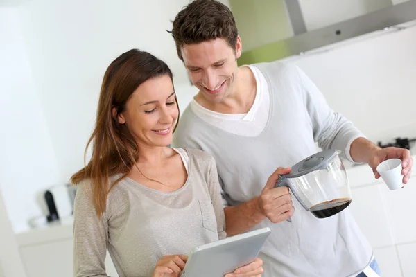 Pareja en casa cocina websurf en internet —  Fotos de Stock