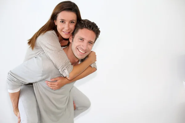 Handsome guy giving piggyback ride to girlfriend — Stock Photo, Image