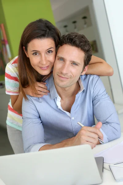 Casal em casa sentado na frente do laptop — Fotografia de Stock