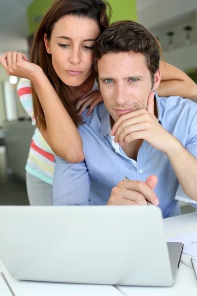 Paret tittar på laptop med förbryllad uttryck — Stockfoto