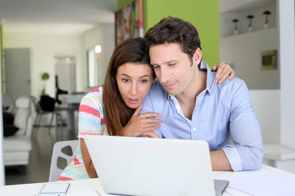 Couple at home sitting in front of laptop — Stock Photo, Image