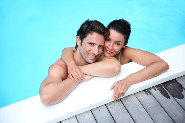 Portrait of cheerful couple in swimming-pool Stock Picture