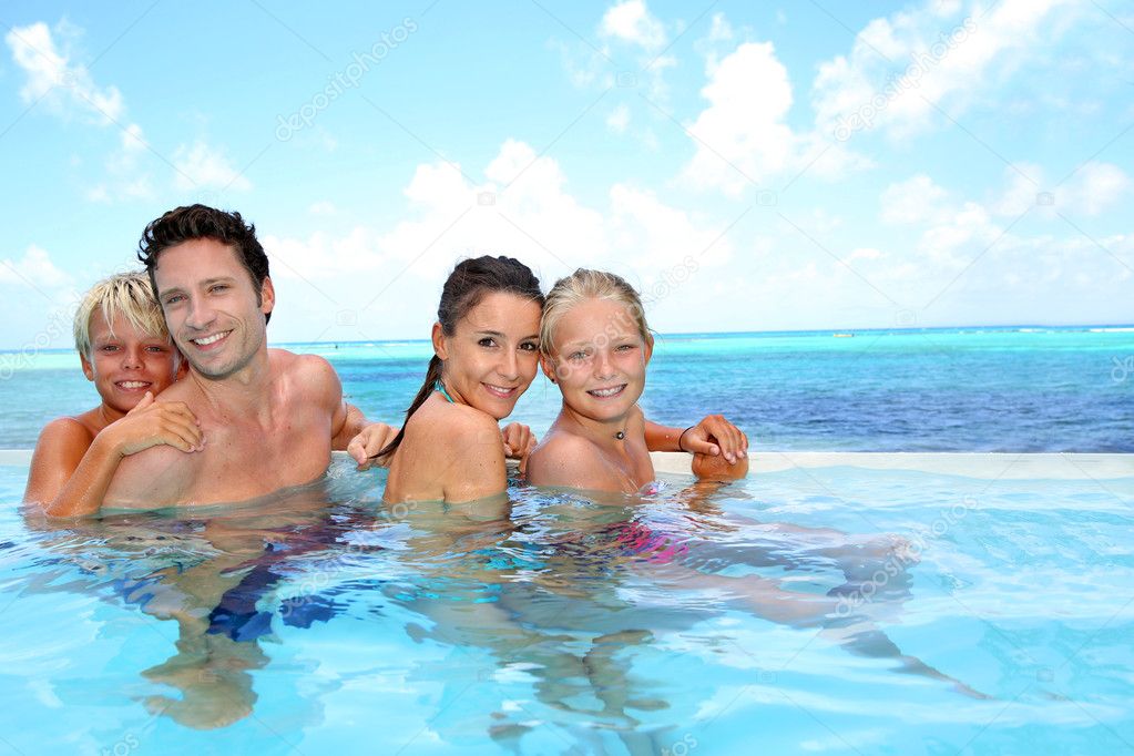 Family of four bathing in swimming pool