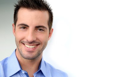 beyaz zemin üzerine eğilerek gülümseyen yakışıklı adam