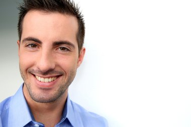 beyaz zemin üzerine eğilerek gülümseyen yakışıklı adam