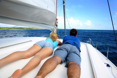 Çift rahatlatıcı seyir ederken bir yelkenli tekne