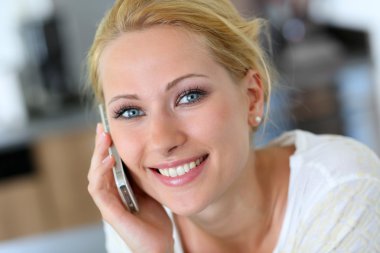 çekici sarışın kadın evde mobilephone üzerinde konuşuyor