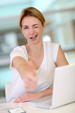 Woman in front of laptop showing thumb up clipart