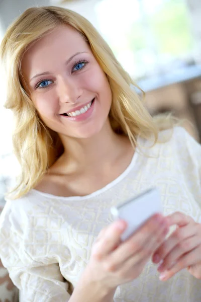 Uśmiechający się blond kobieta rozmowy na telefon z zestawem głośnomówiącym — Zdjęcie stockowe