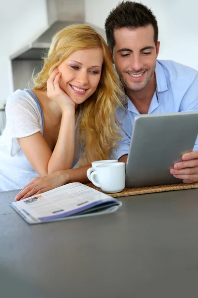 Casal jovem websurf com tablet em casa cozinha — Fotografia de Stock