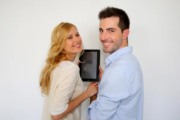 Paar staande op witte achtergrond met Tablet PC — Stockfoto