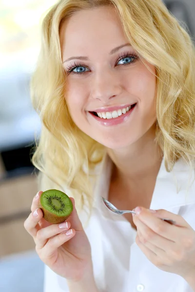 Porträtt av vacker flicka äter kiwi — Stockfoto