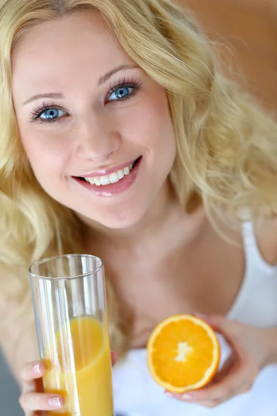 Χαμογελώντας ξανθιά γυναίκα πίνοντας χυμό πορτοκαλιού — Φωτογραφία Αρχείου