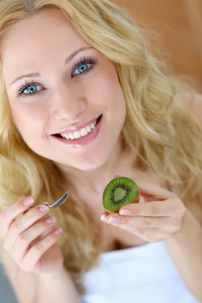 Porträt eines schönen Mädchens, das Kiwi isst — Stockfoto