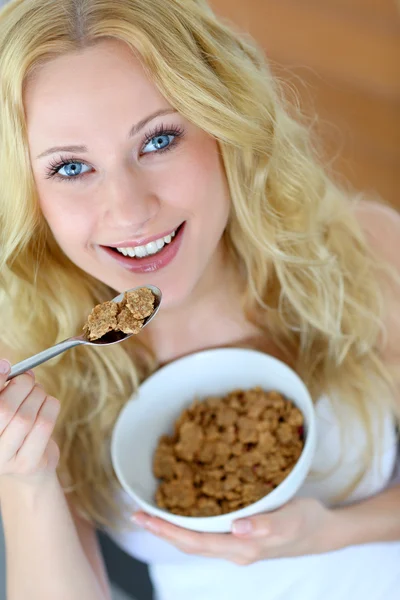 Sonriente chica rubia comiendo cereales para el desayuno —  Fotos de Stock