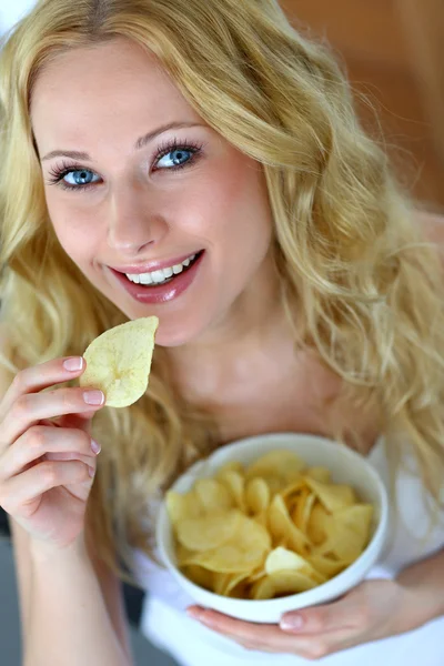 Mujer sonriente comiendo papas fritas —  Fotos de Stock