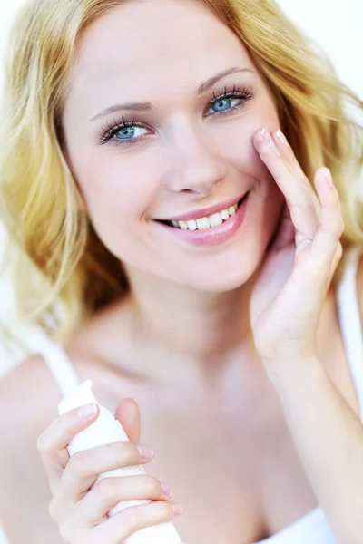 Retrato de mujer hermosa aplicando crema hidratante —  Fotos de Stock