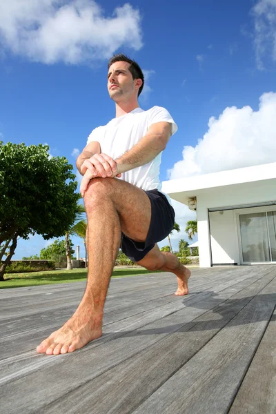 Ung man gör stretching övningar vid poolen — Stockfoto