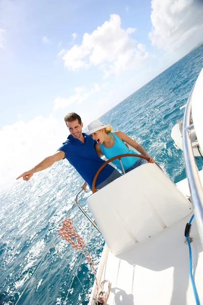 Young couple navigating on a yacht in caribbean sea — Stock Photo, Image
