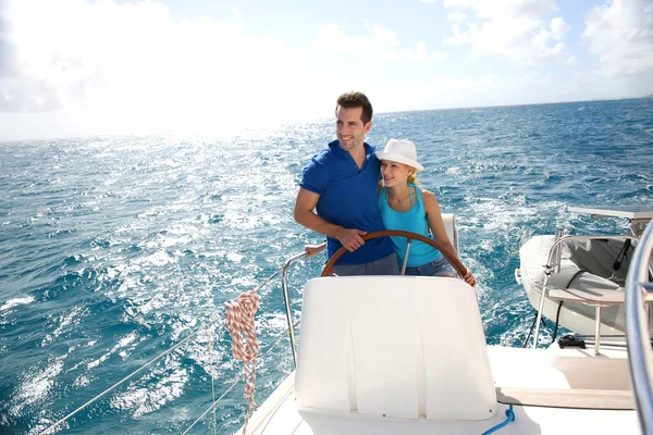 Young couple navigating on a yacht in caribbean sea — Stock Photo, Image