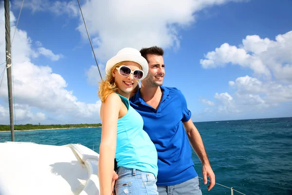 Sonriendo pareja joven rica en un velero en el mar Caribe — Foto de Stock