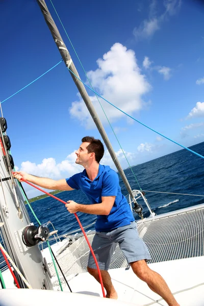 Joven levantando la vela de catamarán durante el crucero —  Fotos de Stock