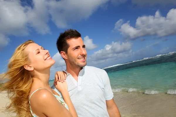 Pareja joven caminando en una playa de arena — Foto de Stock