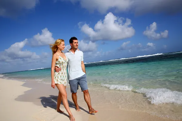 Молодая пара, гуляющая по песчаному пляжу — стоковое фото