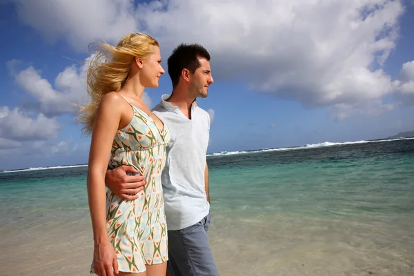 Pareja joven caminando en una playa de arena — Foto de Stock