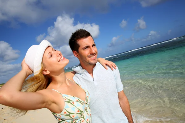 Jeune couple marchant sur une plage de sable — Photo