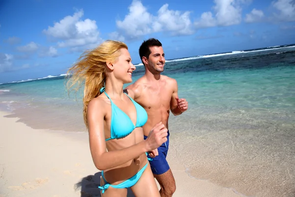 Casal correndo na praia de areia na ilha do caribe — Fotografia de Stock