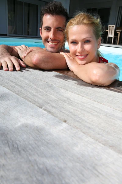 Casal alegre relaxante na piscina — Fotografia de Stock