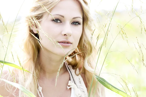 Glamorous young woman standing in meadow — Stock Photo, Image