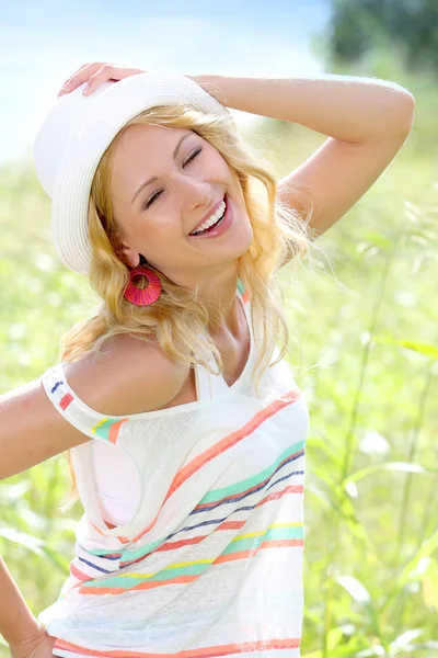 Ragazza sorridente in campagna indossando cappello — Foto Stock