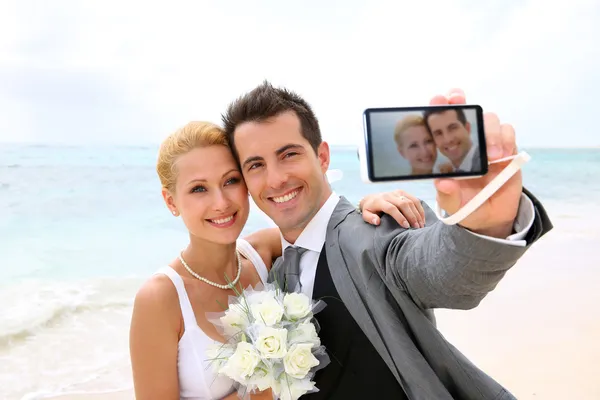 Bruid en bruidegom nemen foto van zichzelf — Stockfoto