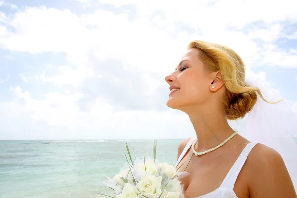 Portrait of beautiful bride with eyes shut by the beach — Stock Photo, Image