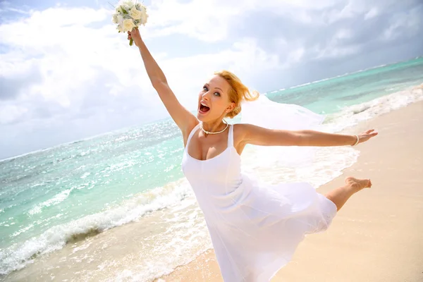 Fröhliche Braut zeigt Glück am Strand — Stockfoto