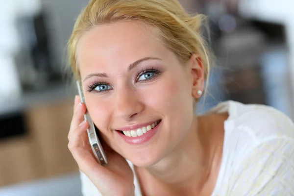 Přitažlivá blondýnka doma mluví na mobilní telefon — Stock fotografie