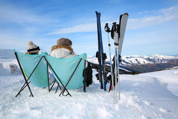 Casal de esquiadores relaxando em cadeiras longas — Fotografia de Stock