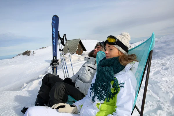 Couple de skieurs se relaxant dans des chaises longues — Photo