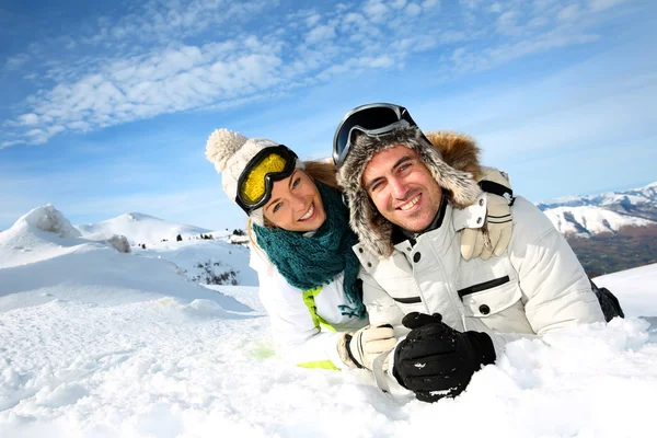 Couple of skiers laying down in the snow — Stock Photo, Image