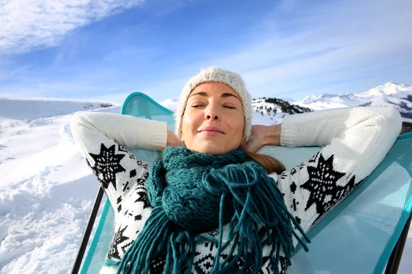 Woman in ski resort relaxing in long chair — Stock Photo, Image