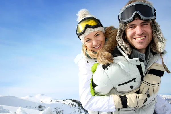 Alegre snowboarder segurando namorada em suas costas — Fotografia de Stock