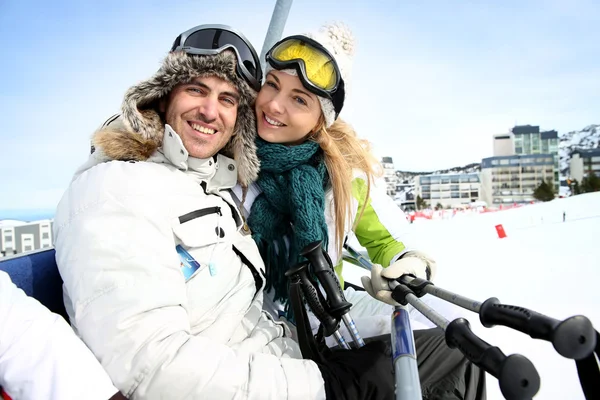 Paar van skiërs zittend op liftchairs in sneeuw resort — Stockfoto