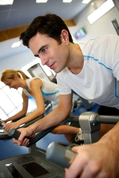 Uomo che si allena in bicicletta nella sala fitness — Foto Stock