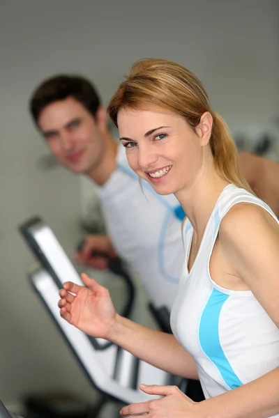 Couple in fitness gym using running belt — Stock Photo, Image